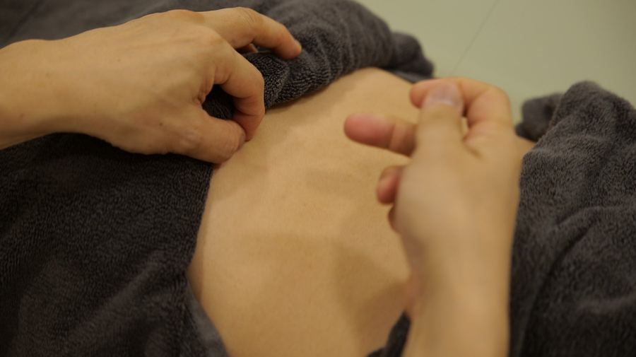 お腹まわりに触れて確かめている様子